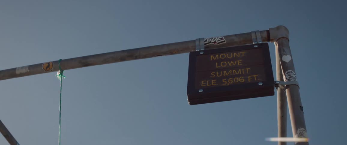 A hanging metal sign with an address