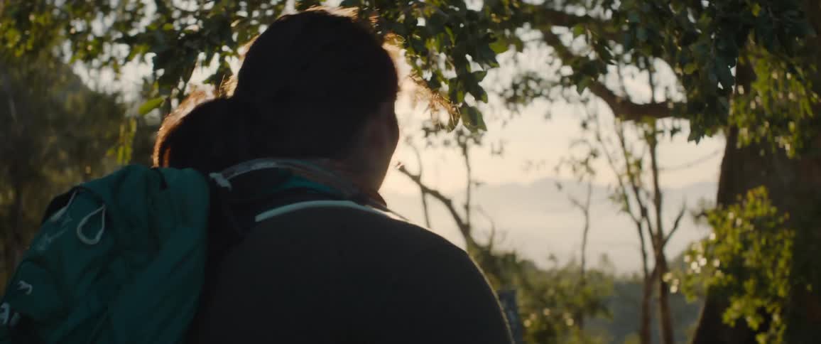 Woman wearing backpack treks outdoors with group of people