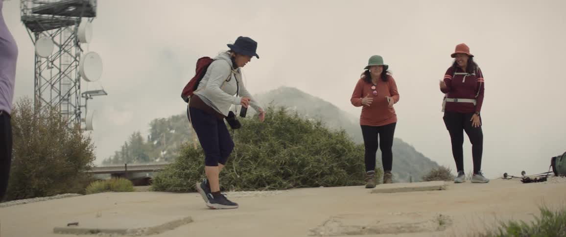 Friends chatting and smiling in trail attire on a terrace