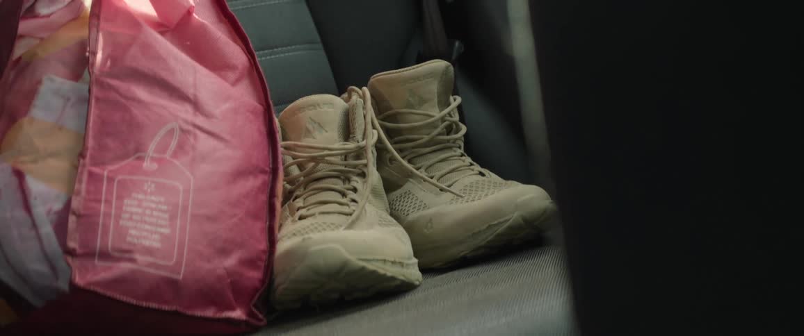 Tan lace up ankle boots on seat near bag