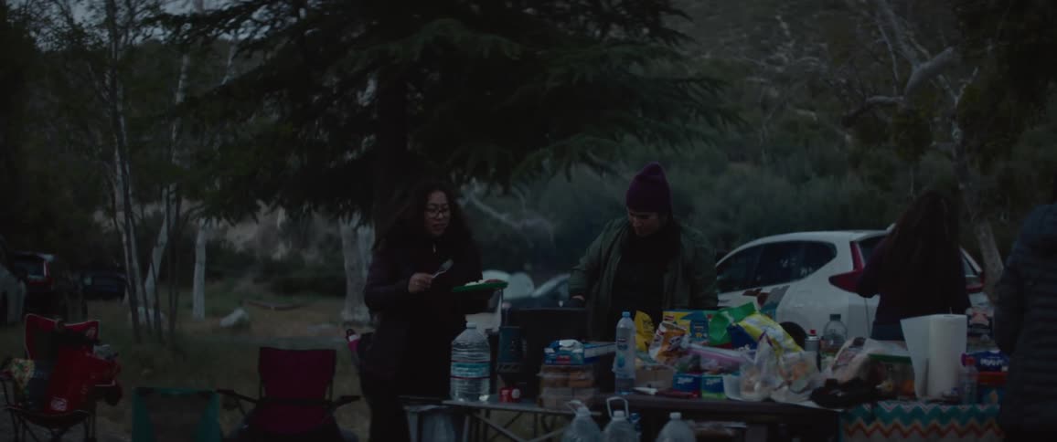 Group of people prepare meal at camp in the forest