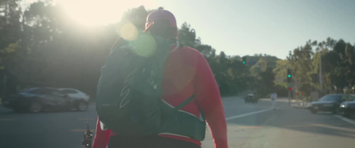 Woman with her back turned equipped for hiking walking alongside a highway