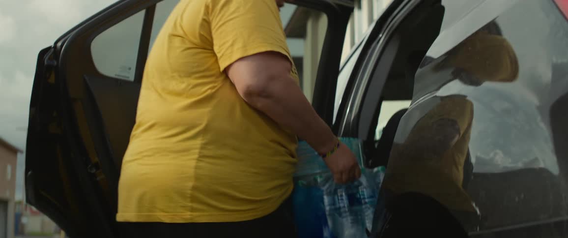 A woman taking a case of bottled water out of her car
