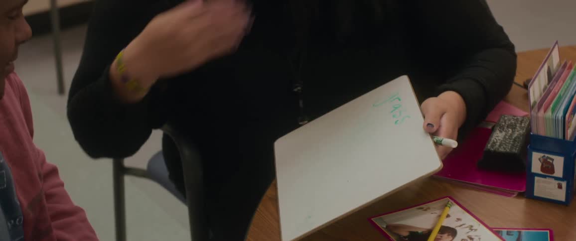 Female teacher tutors adult using flashcards during a lesson
