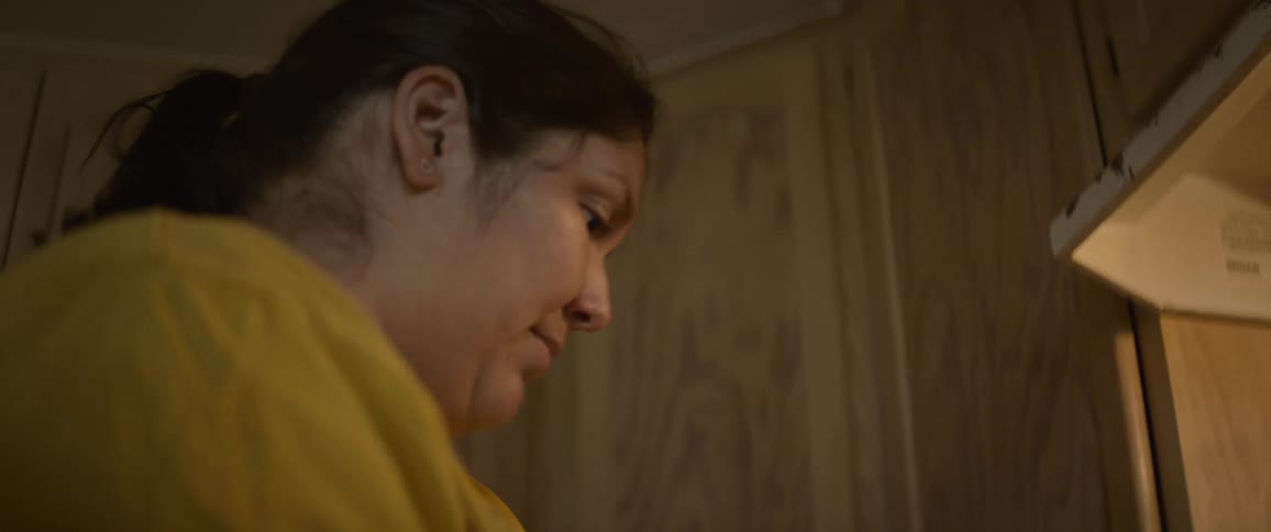 Woman prepares meal while standing near stove in kitchen at home