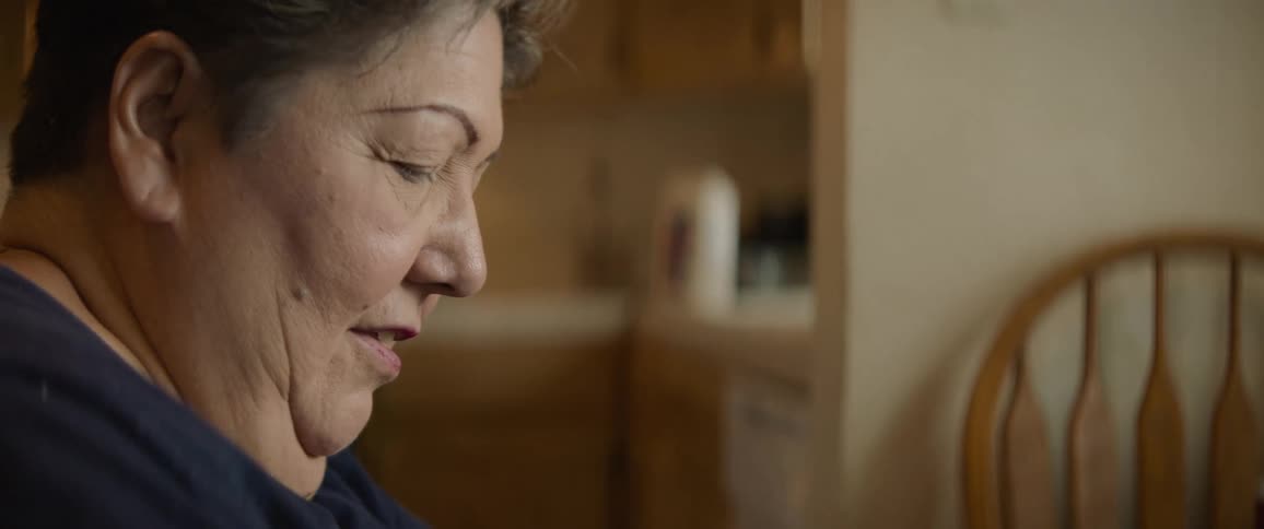 Woman sits at kitchen table prepping items for cooking