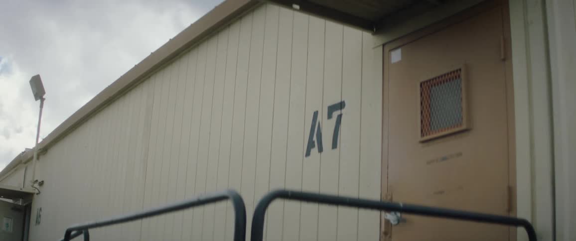 Building label decorates wall next to business entrance under a cloudy sky