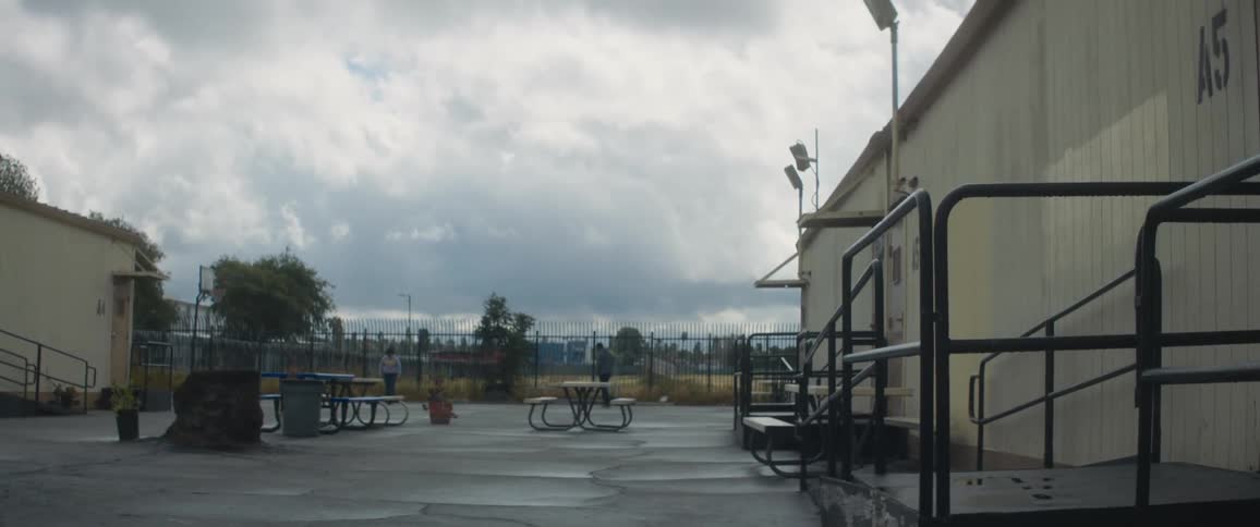 Two people walking in an outdoor area of a factory