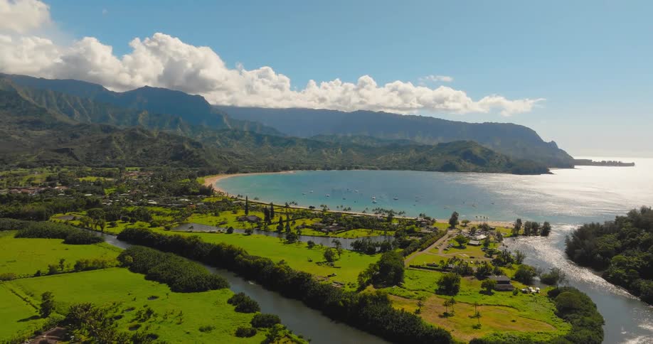 Aerial view of ocean bay near mountains and green land during the day