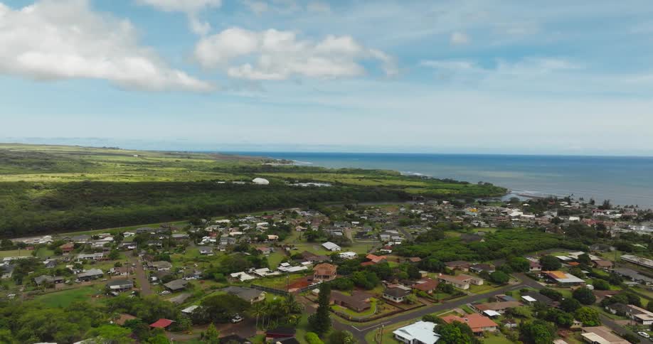 Residential neighborhood borders forest and ocean on a cloudy day