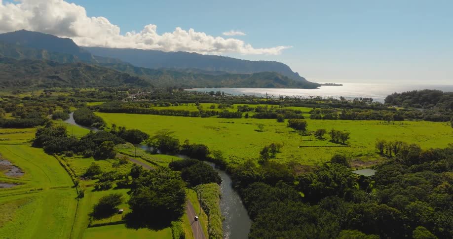 Aerial View of Tropical Island Bay with Mountains and Lush Green Fields