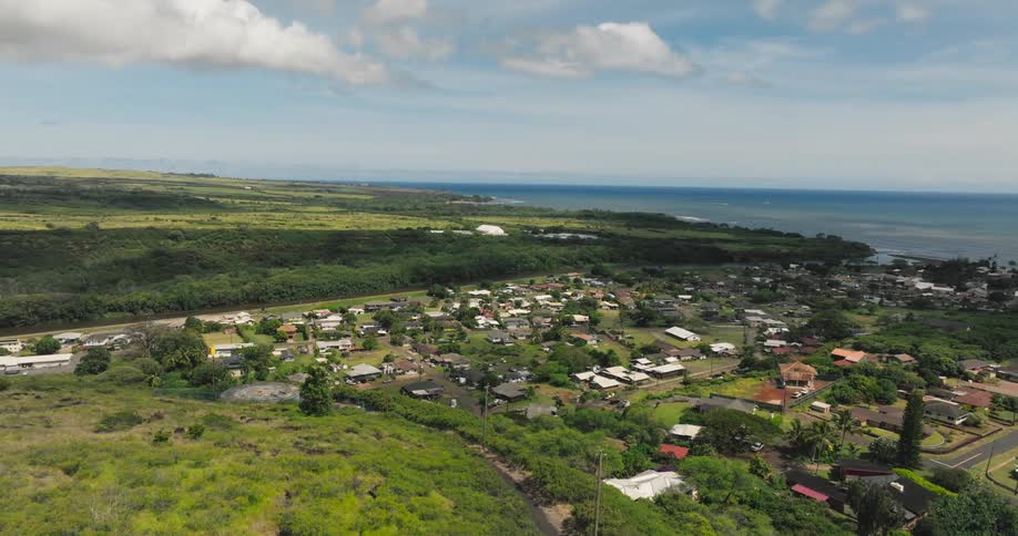 Aerial landscape of an urban area next to hills to one side and the ocean to the other during day time