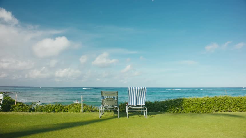 Beach chairs in a backyard facing the beach