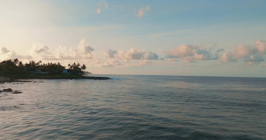 Flying Over Crashing Waves Offshore from an Island at Sunrise