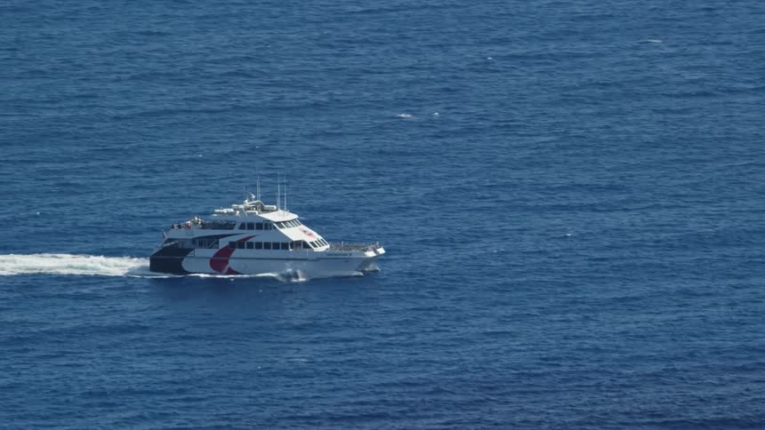 Yacht moves across ocean creating white wake