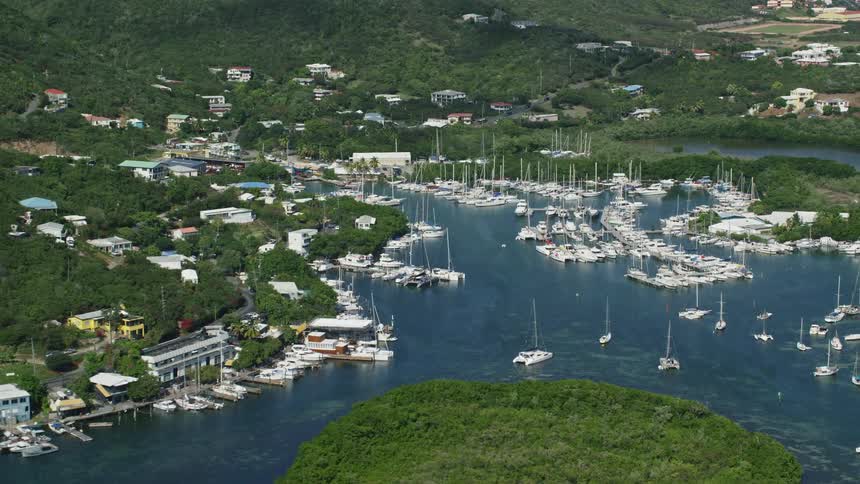 The island shore is covered with anchored boats