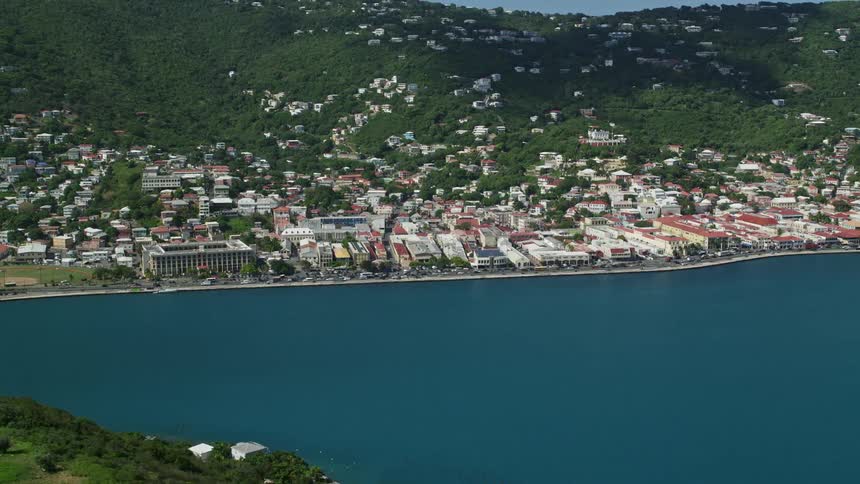 Skyline of a coastal city between forested mountains