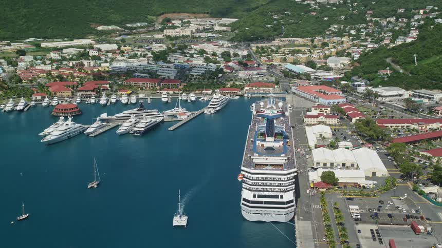 Aerial view of a cruise ship docked on the port of a small coastal town