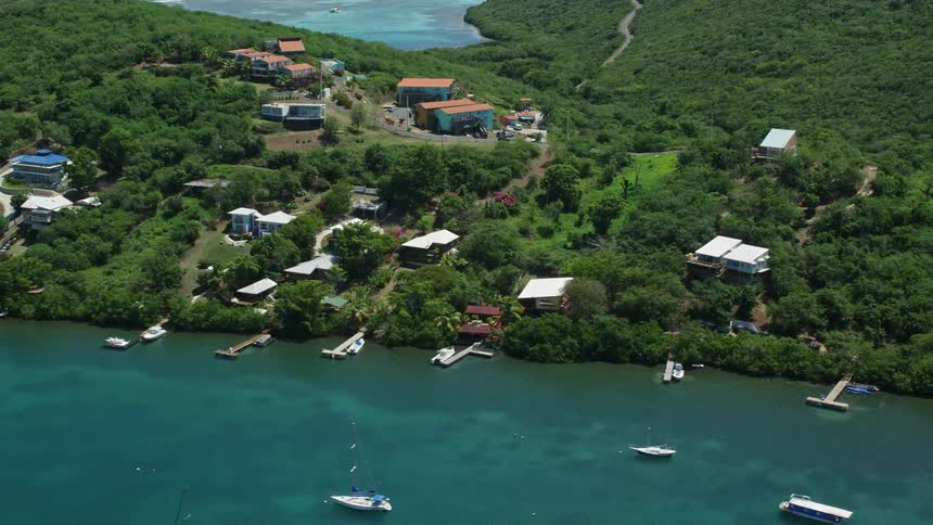 Aerial view homes and boats near blue ocean bay