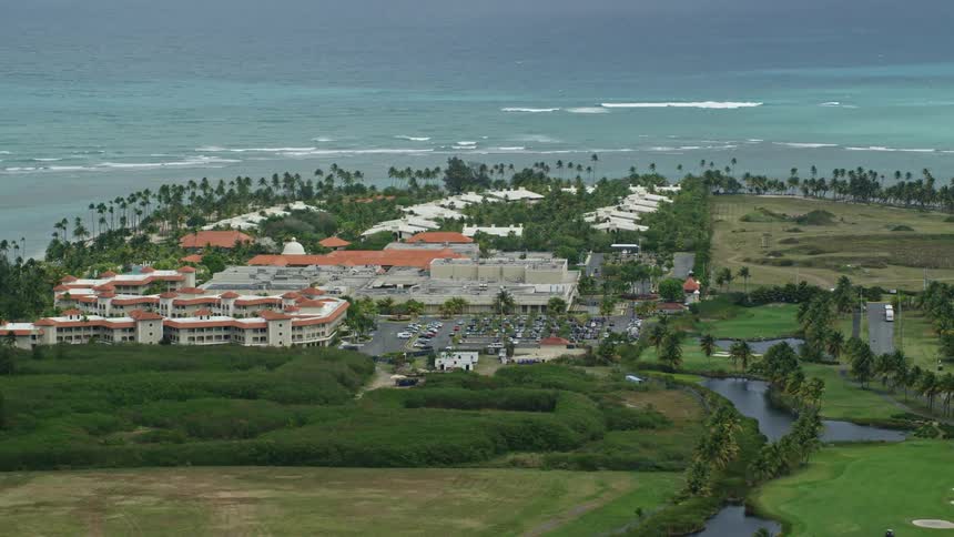 Road passes between apartment buildings and golf course on peninsula