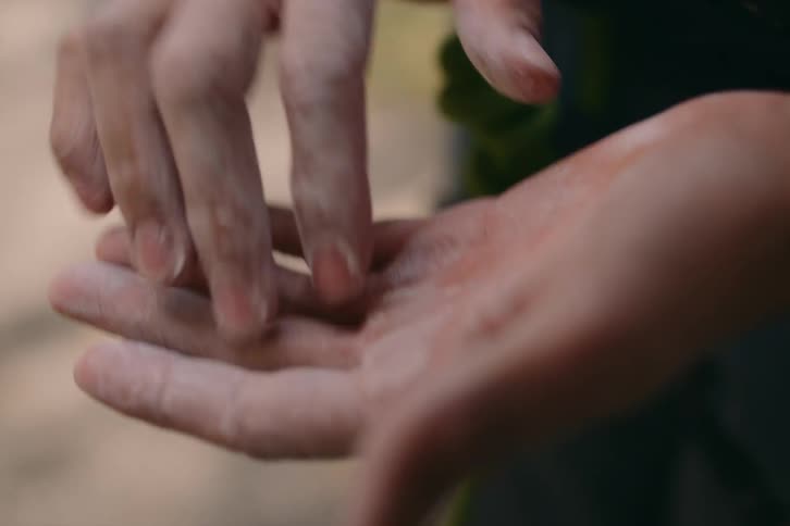 A person is rubbing the fingers of one hand against the other and their hand is dirty