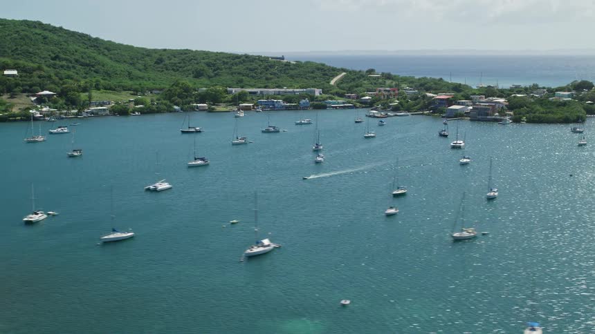 Skyline of a paradisiacal island with yachts anchored off the coast
