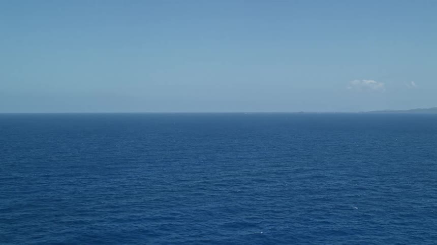 Aerial panorama of the blue ocean with a sky with very few clouds