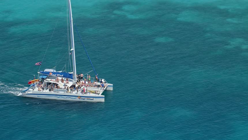 Several boaters on a cuban sailboat in the middle of the ocean