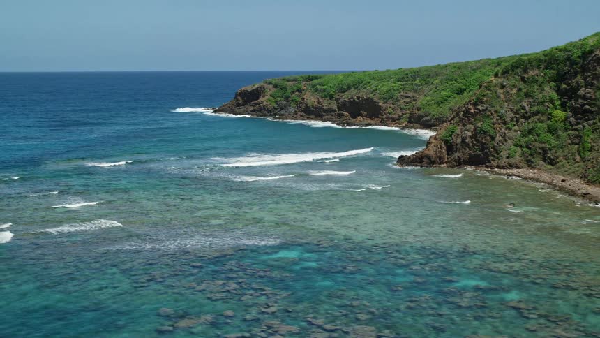 Aerial panorama of the sea and a bay with mountains and vegetation
