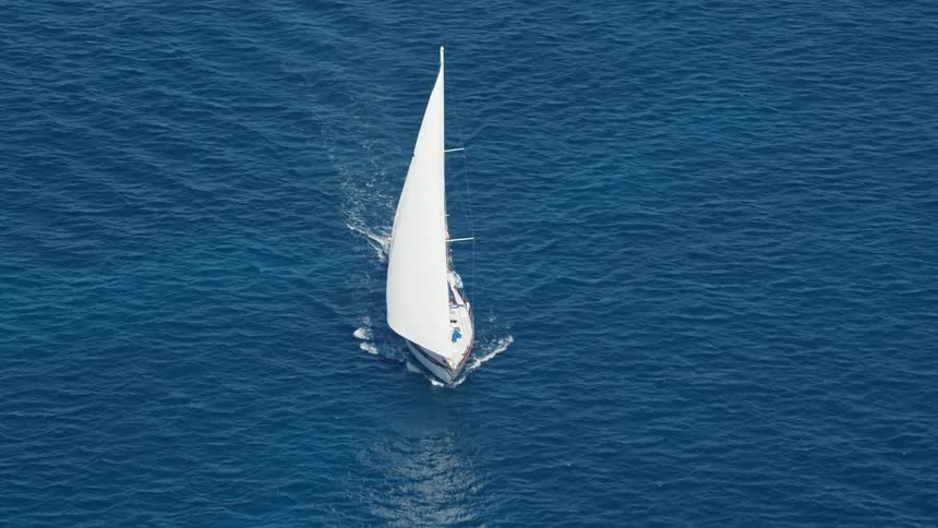 A white sailboat sailing on an ocean