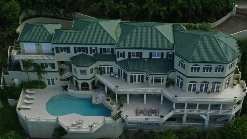 Aerial view of coastal estates on tree lined cliff near ocean