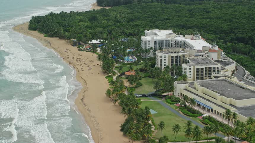 Aerial view of tourists enjoying the beach in front of a resort