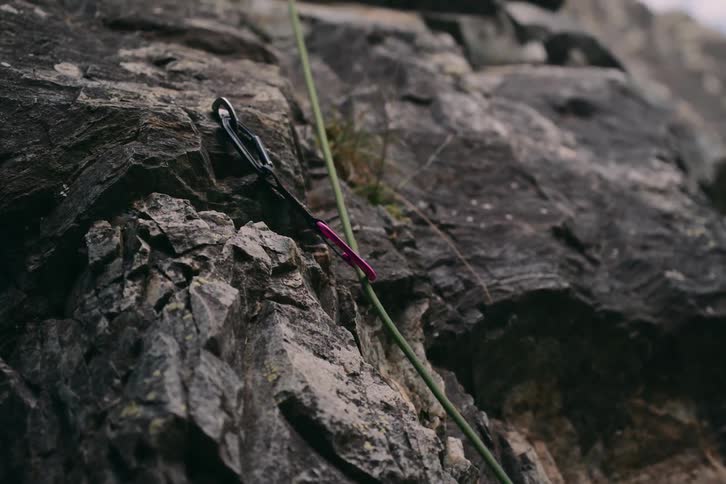 Closeup of a rope attached to a mountain climbing safety anchor