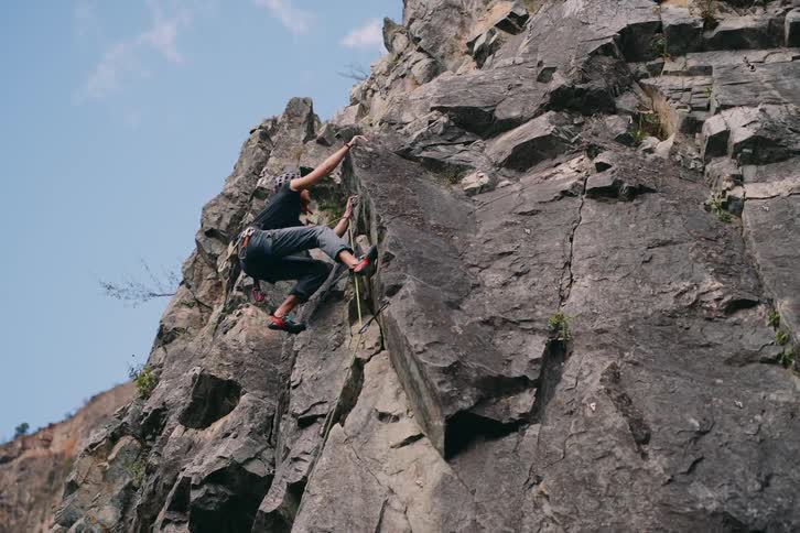 Woman climbing a steep rocky slope