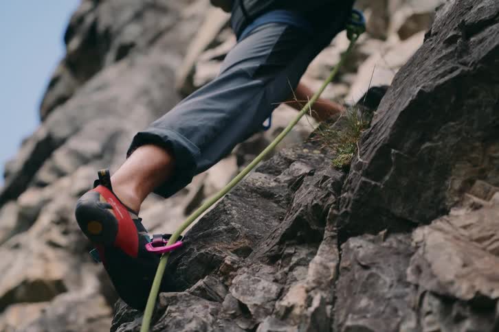 Close up of the legs of a rock climber on a cliff