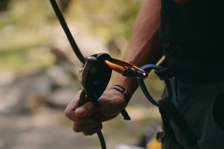 A rock climber pulls on the rope attached to his belt