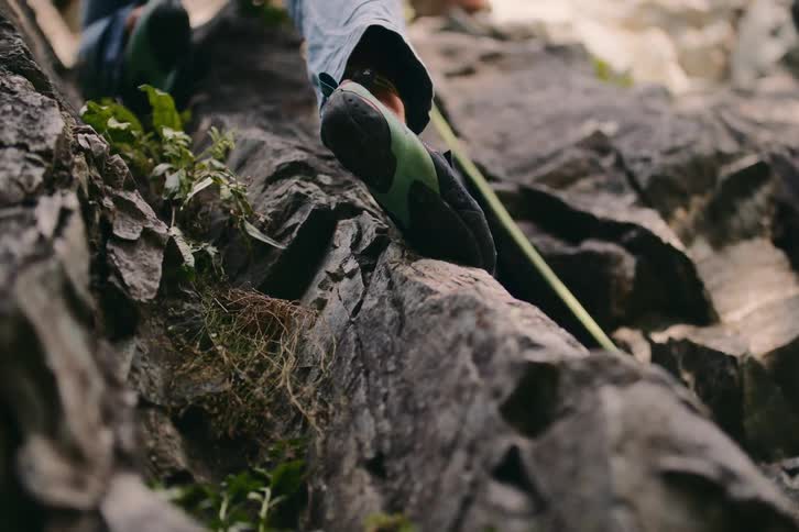 Close up of the legs of a rock climber on a cliff