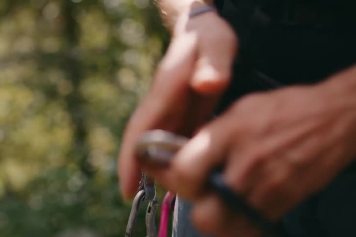 Closeup of a mans hands adjusting safety harness straps