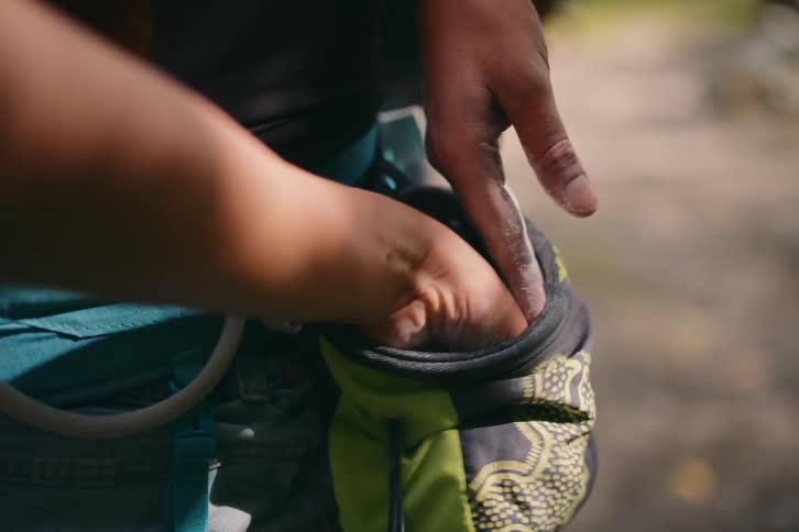 A person keeping something in a small cloth bag