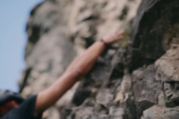 A rock climber attaches a clasp in the stone as he climbs