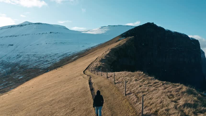 A clip of a person walking at the top of a hill