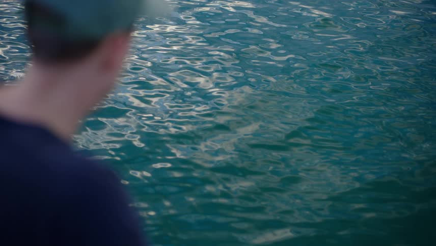 A man looking at ripples on the water