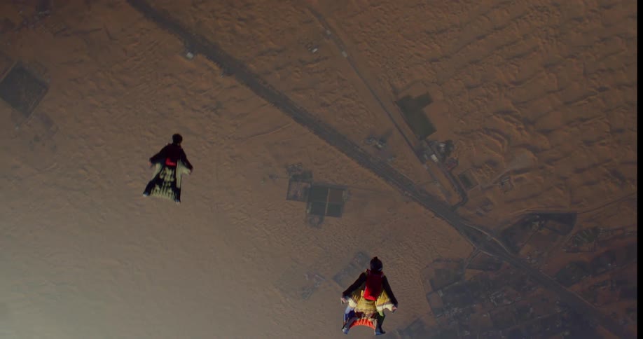 Two people skydiving outdoors over the desert