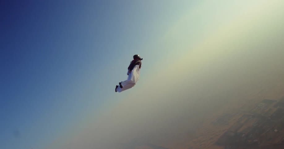 A skydiver is gliding with a wing suit then his parachute opens