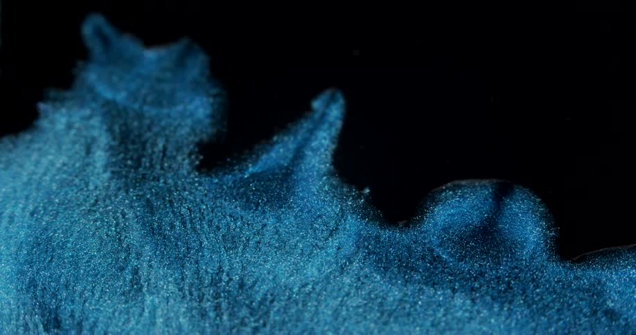 Blue liquid glitter slowly sliding forward
