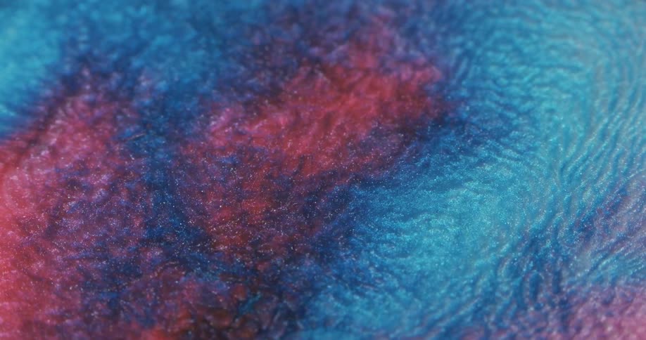 Blue and red liquid glitter moving and slowly mixing