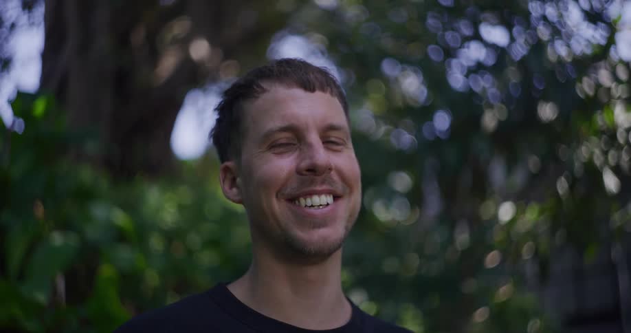 A face of a man who is smiling and showing his teeth
