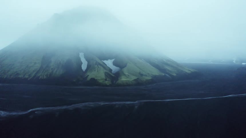 An aerial view of a mountain at the edge of the ocean