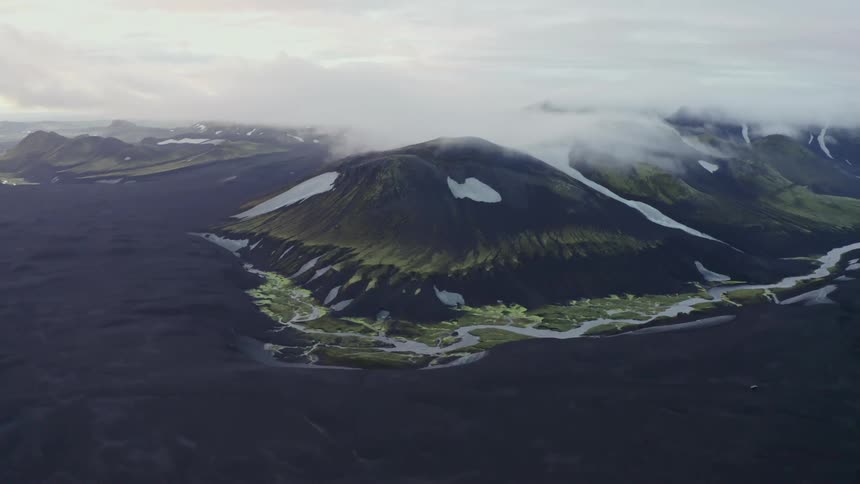 Aerial of a volcanic mountain covered in mist