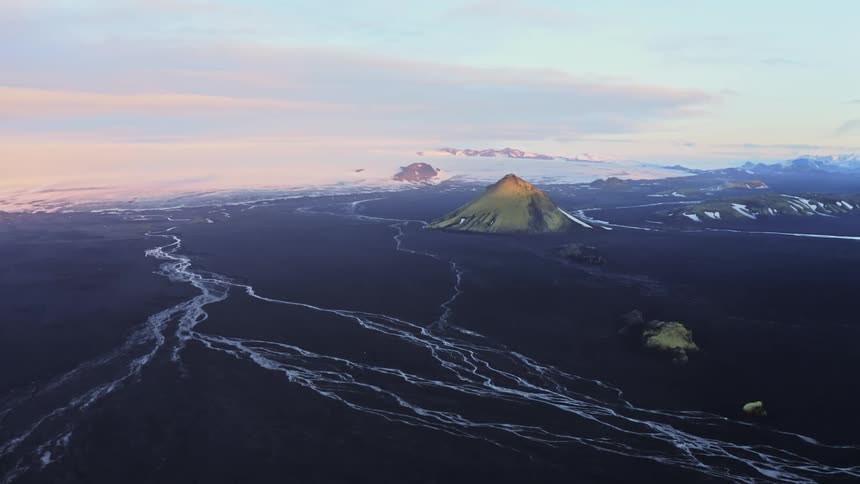 Aerial panorama of mountains and a volcano on black soil on a winter morning
